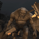 A first person view of how reloading a gun in RE4 in VR looks, featuring a large troll in the background.